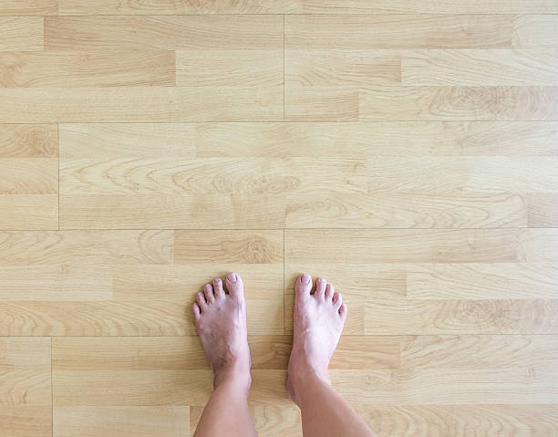 A little girl's feet on hardwood floor.
