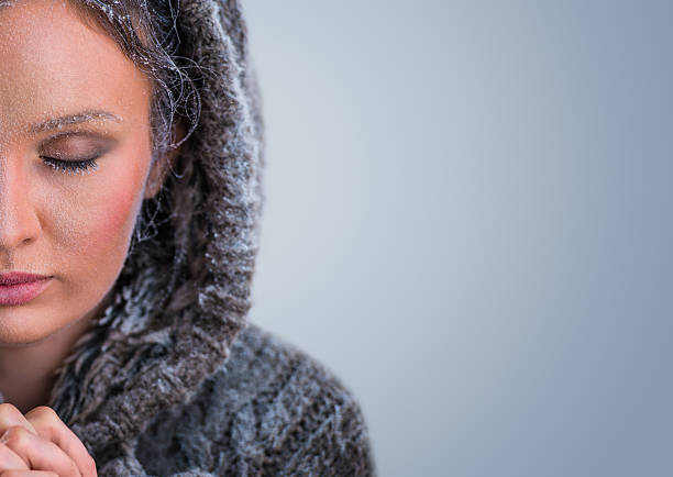 Adult woman Blowing into her Hands on a Cold Winter day