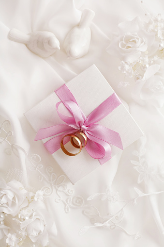 wedding background with wedding rings, gift box and flowers