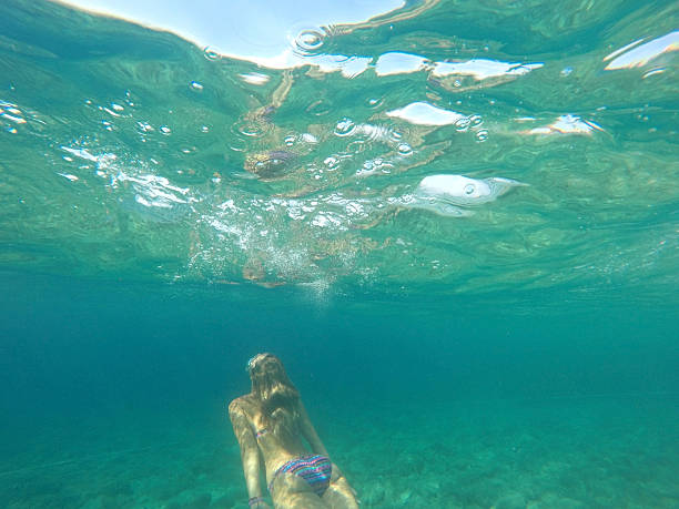 Young woman diving in blue sea - fotografia de stock