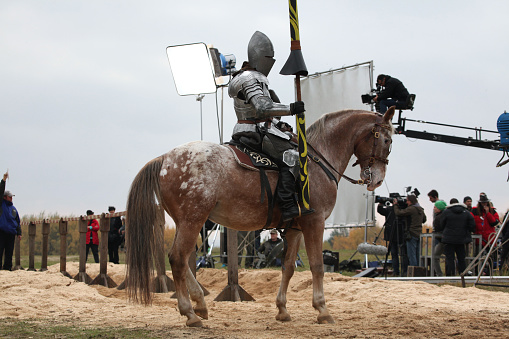 Milovice, Czech Republic - October 23, 2013: Actor dressed as a medieval knight rides a horse during the filming of the new movie The Knights directed by Carsten Gutschmidt near Milovice, Czech Republic.