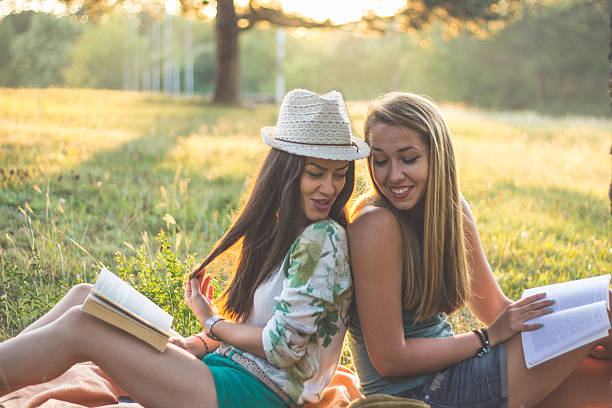 istock Young smiling women relaxing in nature and studying 592397884