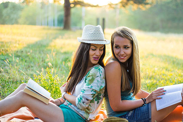 istock Young smiling women relaxing in nature and studying 592397990