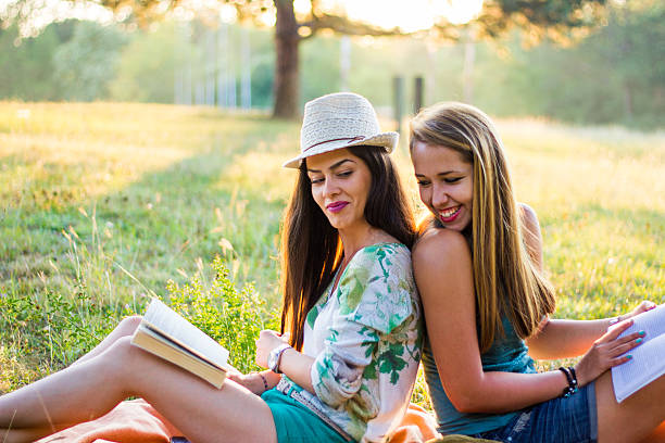 istock Young smiling women relaxing in nature and studying 592398082
