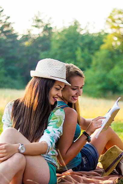 istock Young smiling women relaxing in nature and studying 592398272