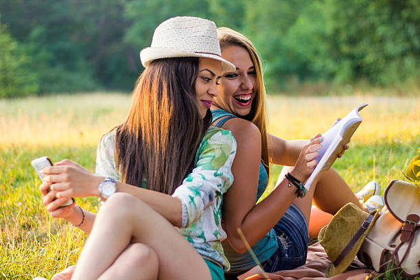 istock Young smiling women relaxing in nature and studying 592398378