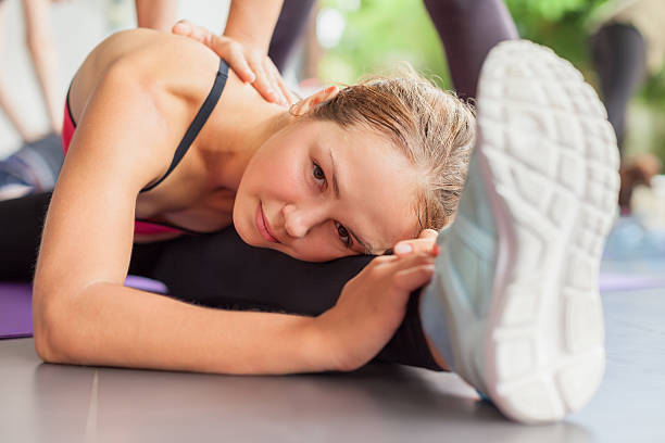 gruppo di persone che si allungano con istruttore di fitness nelle lezioni di pilates - lying down moving down pilates yoga foto e immagini stock