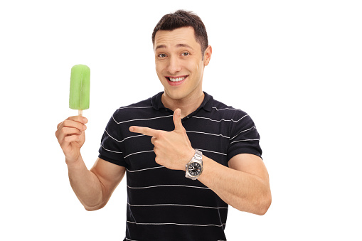 Smiling guy holding an ice cream and pointing at it isolated on white background