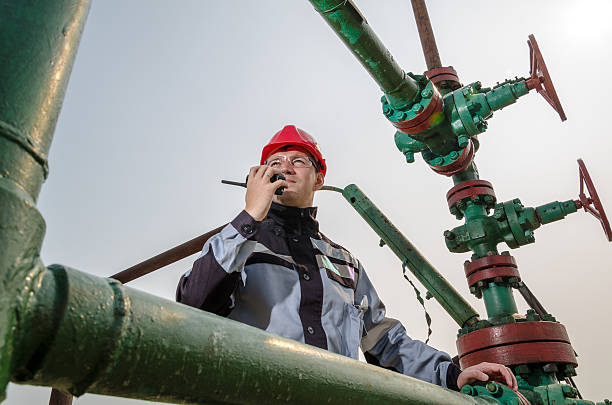 worker near wellhead - mining engineer oil industry construction site imagens e fotografias de stock