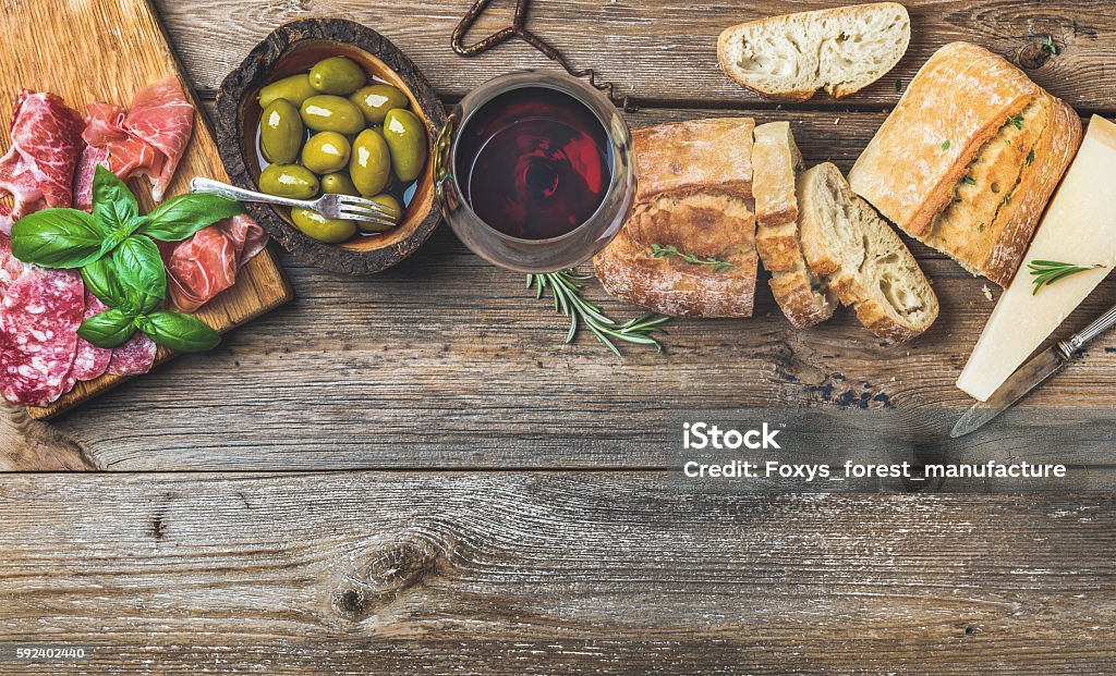 Set de aperitivos de vino y copa de fondo rojo sobre madera - Foto de stock de Vino libre de derechos