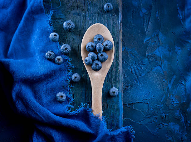 Pile of fresh blueberries on wooden spoon stock photo