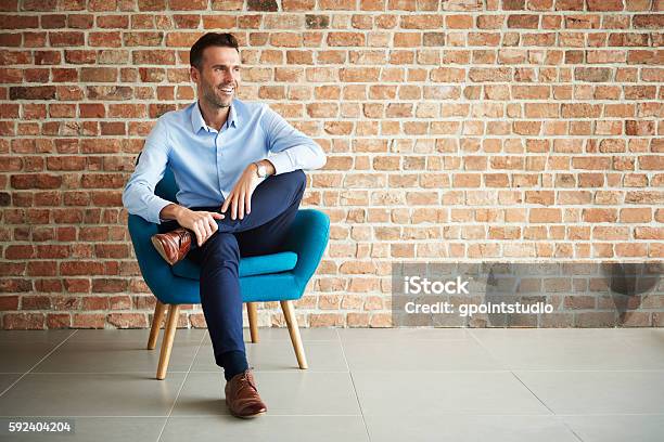 Businessman Sitting In The Armchair Stock Photo - Download Image Now - Men, Sitting, Legs Crossed At Knee