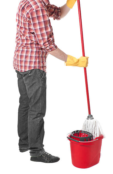 istock man puts the mop in a bucket 592406884
