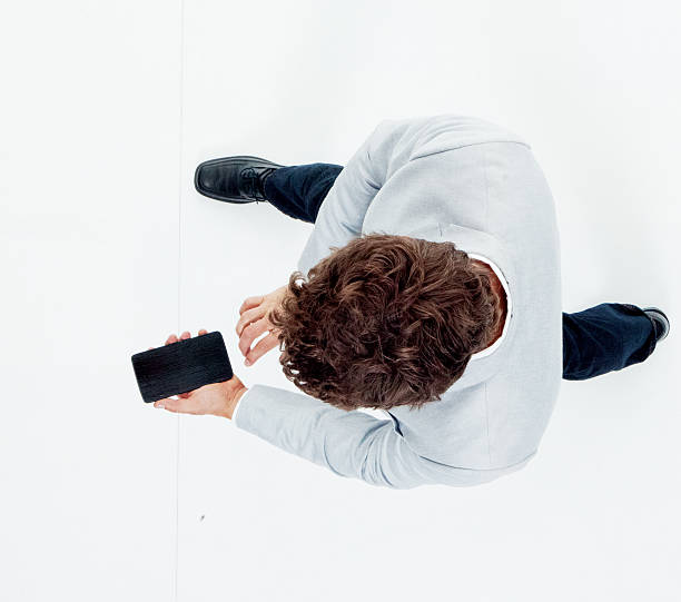 istock Above view of smart casual man using phone 592408282