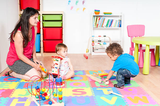 istock Carers And Babies/ Toddlers Playing in Nursey 592408394