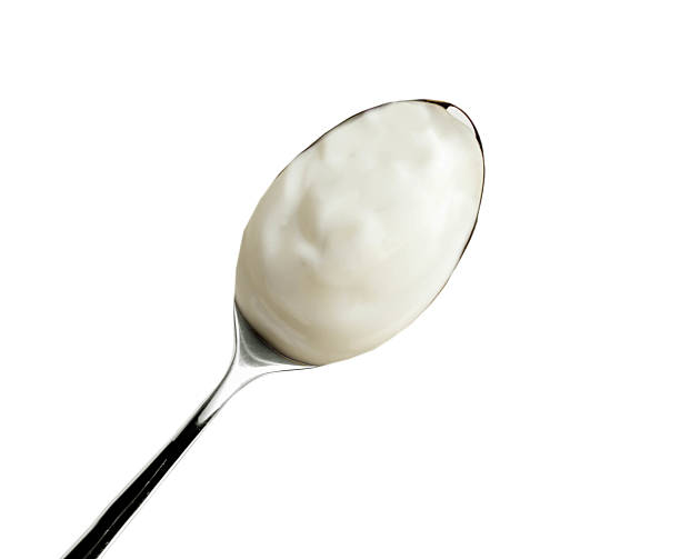 istock Spoon of yogurt isolated on white 592408460