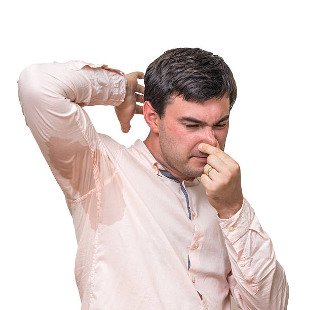 istock Man with sweating under armpit pinches nose with fingers 592409134