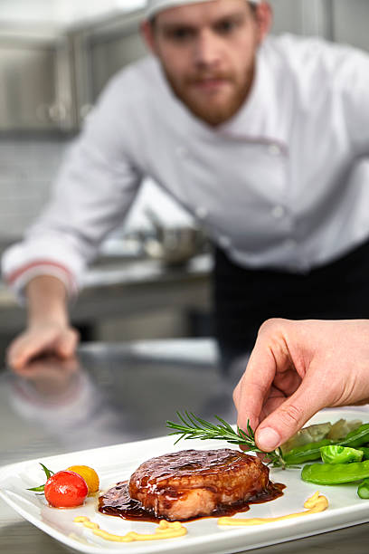 istock Male chef preparing steak plate 592409150