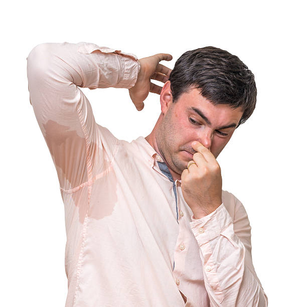 istock Man with sweating under armpit pinches nose with fingers 592409152