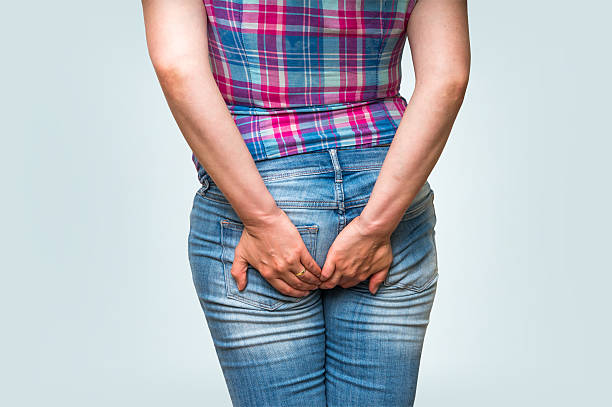 istock Woman holding her butt isolated on blue background 592409358