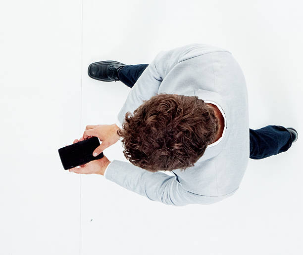 istock Above view of smart casual man using phone 592642020