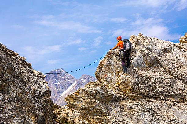istock Mountain Climber on rocky ridge with rope and safety gear 592643802
