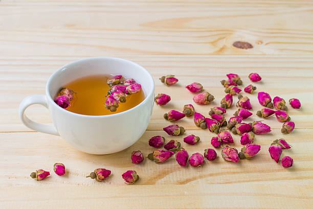 istock Cup of rose tea on wooden background 592643946