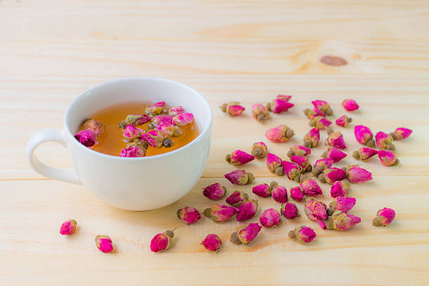 istock Cup of rose tea on wooden background , soft effect 592644008