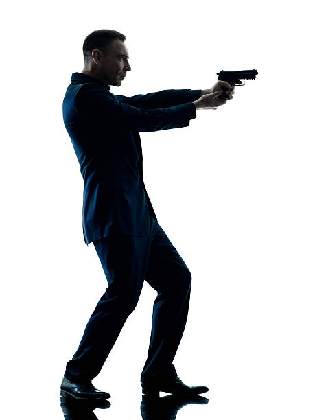 istock man with a handgun silhouette isolated 592644262