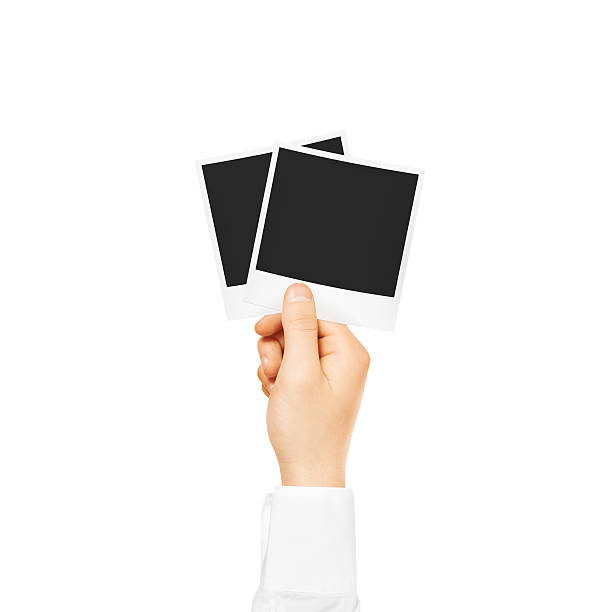 istock Hand holding blank photo frames mockup isolated 592645158