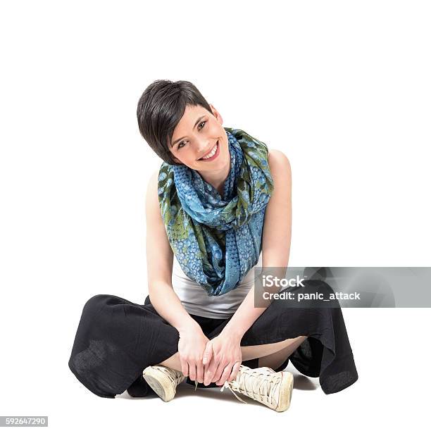 Charming Girl Sitting Crosslegged Smiling At Camera With Slanted Head Stock Photo - Download Image Now