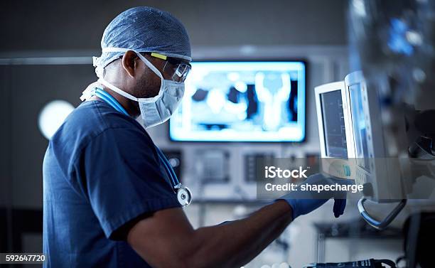 Vigilantly Monitoring His Patients Vitals Stock Photo - Download Image Now - Healthcare And Medicine, Technology, Hospital