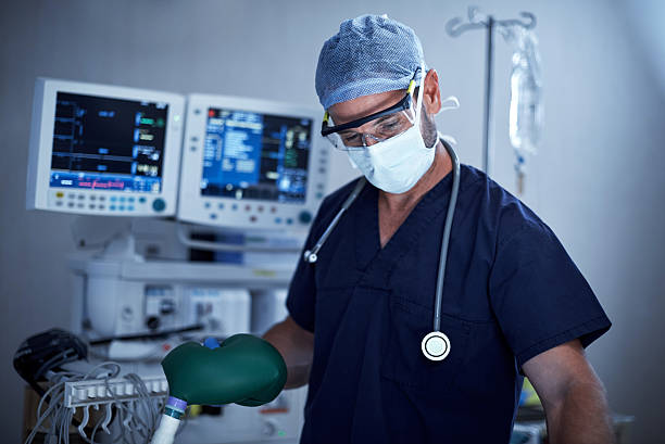 Anesthesiologists are vital members of any surgical team Shot of a surgeon administering oxygen during surgery anaesthetist stock pictures, royalty-free photos & images