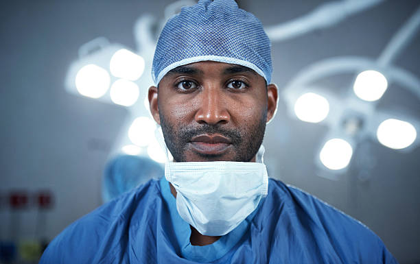 My surgeries come with a high success rate Portrait of a confident young surgeon standing in an operating room surgeon stock pictures, royalty-free photos & images