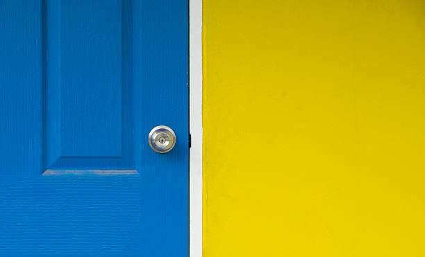 istock the yellow wall and close blue door for background 592650328
