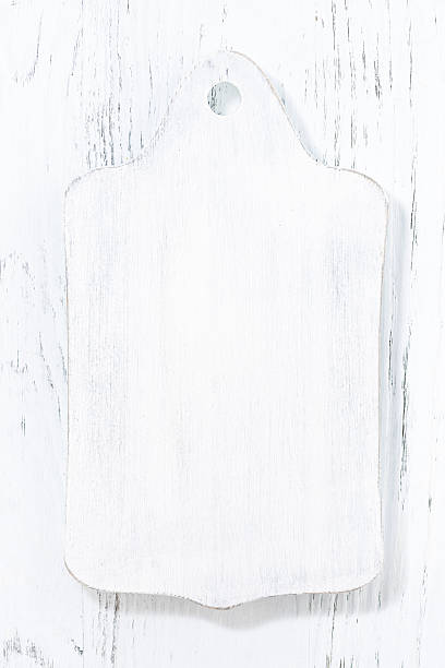 white cutting board on a wooden background, top view