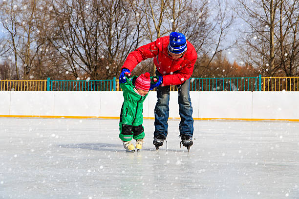istock father and child learning to skate in winter 592650766