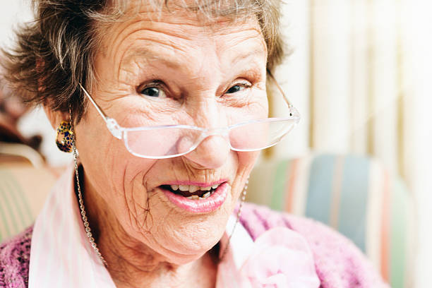 istock Smiling senior woman peeps over her spectacles 592652934