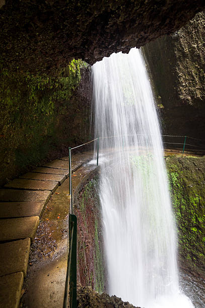 istock Waterfall over the Levada Nova hiking path, Madeira island. 592654022
