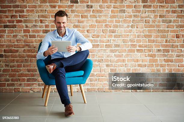 Digital Tablet Used By Handsome Man Stock Photo - Download Image Now - Sitting, Men, Businessman