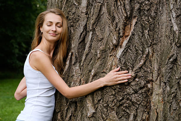 istock Young woman hugging big tree 592658212
