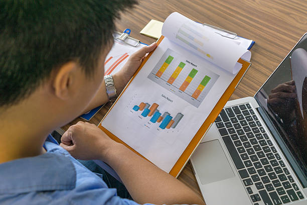 istock Asian employee checking sales report in office room 592658636