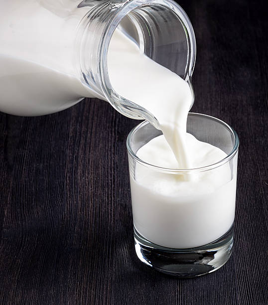 istock Milk pouring into a glass on black board 592659742