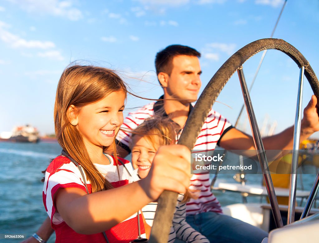 Young father with adorable daughters on a big boat Young father with adorable daughters resting on a big boat Family Stock Photo