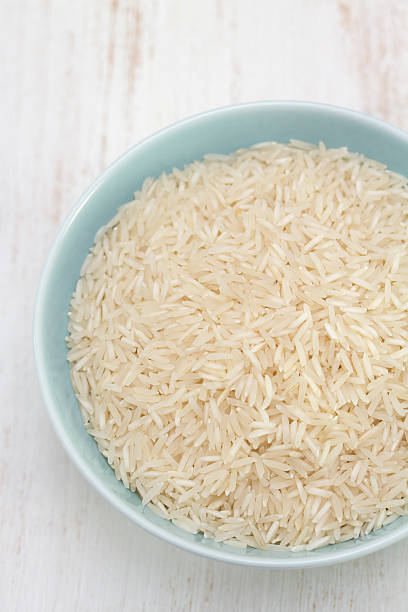 istock raw rice on blue bowl on white wooden background 592663748