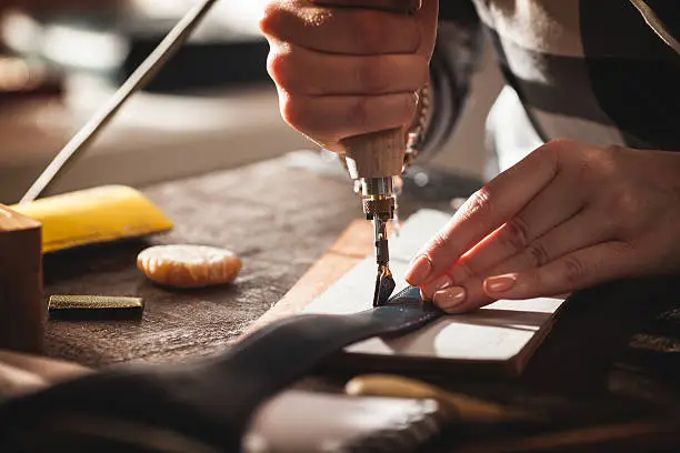 Leather handbag craftsman at work in a workshop