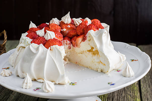 Sliced Pavlova Cake with Strawberries on White Plate stock photo