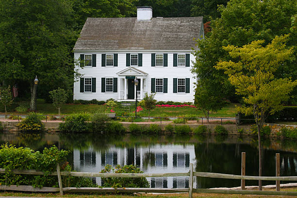 luxuriöses new england house on a pond among trees, massachusetts. - house colonial style residential structure new england stock-fotos und bilder