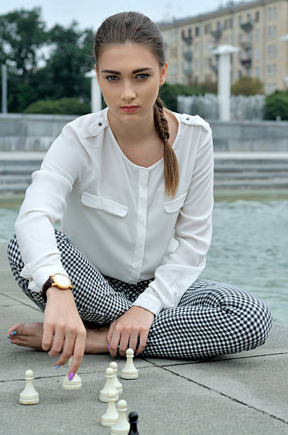 istock Woman puts a pawn on granite. 592667270