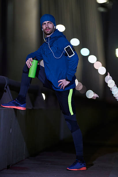 istock Man jogging through the city at night 592667324